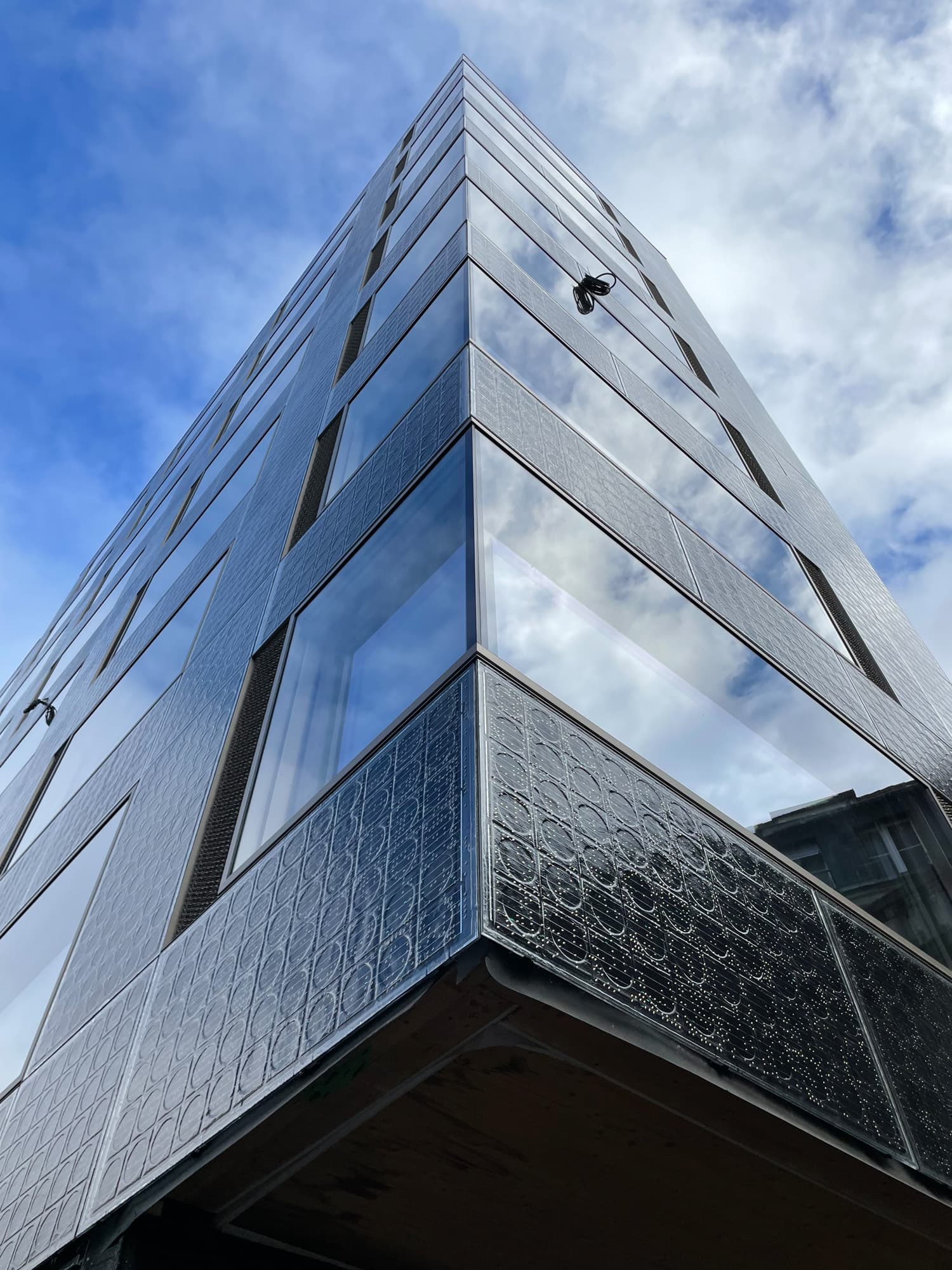 Hochhaus mit grossflächige Fensterfronten und Photovoltaik-Fassade