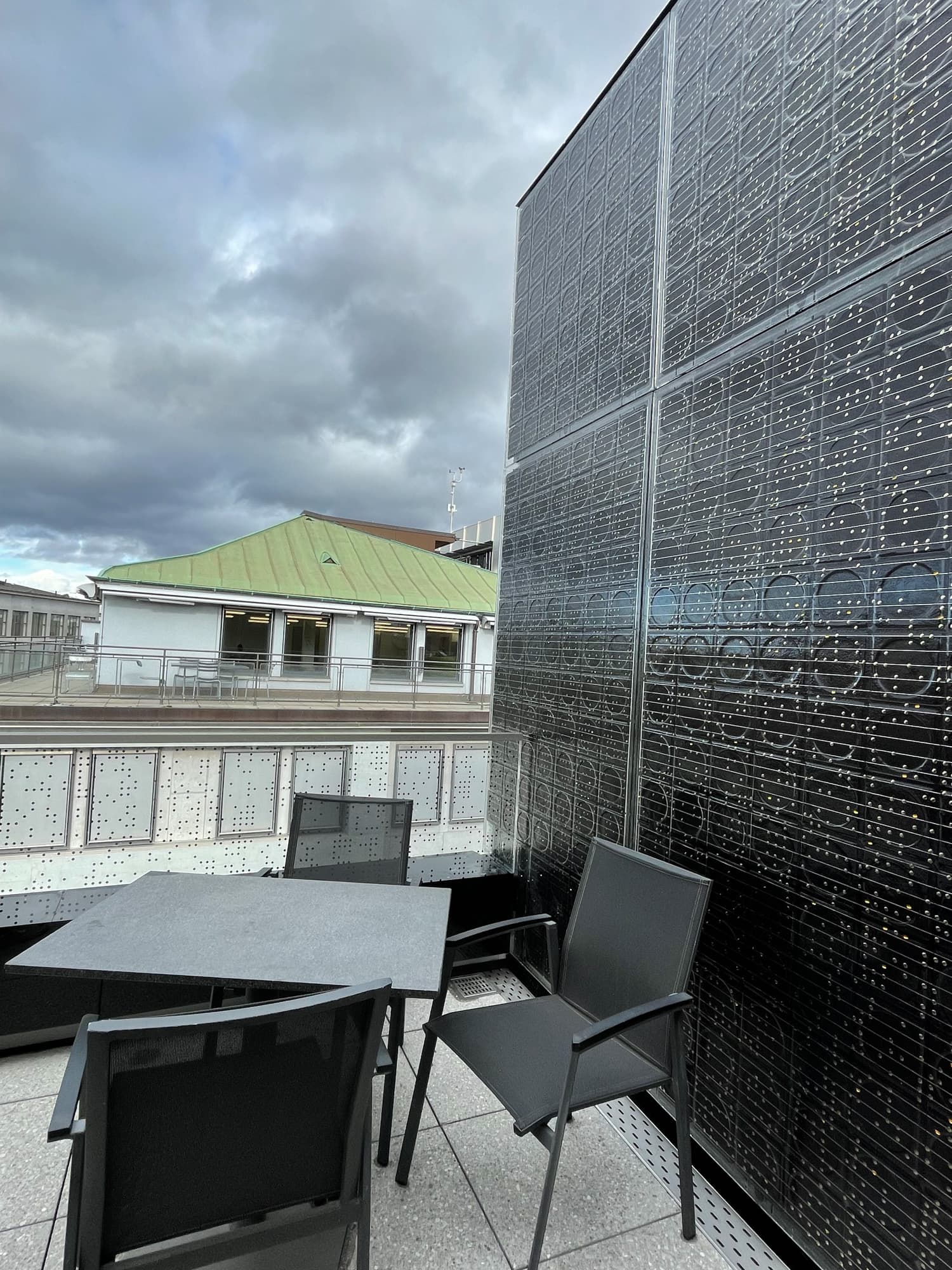Eine Dachterrasse mit Tisch und Stühlen