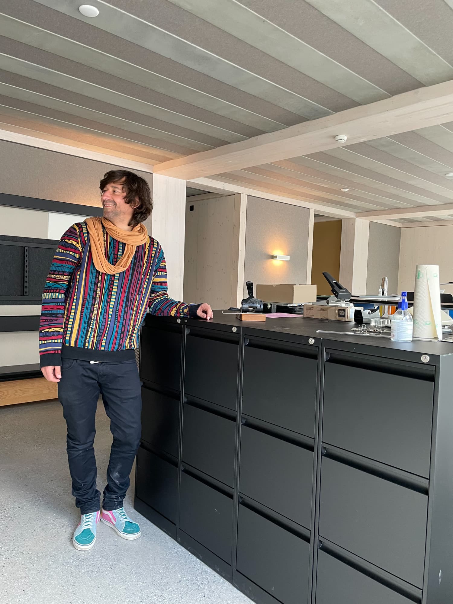 Harald Hikel steht angelehnt an einen Aktenschrank in einem Büro.