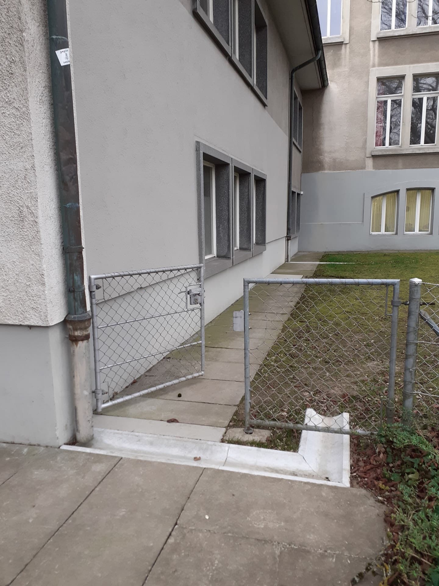Haus mit Regenrinne und kleinem Kanal, der das Wasser in eine Wiese ableitet.
